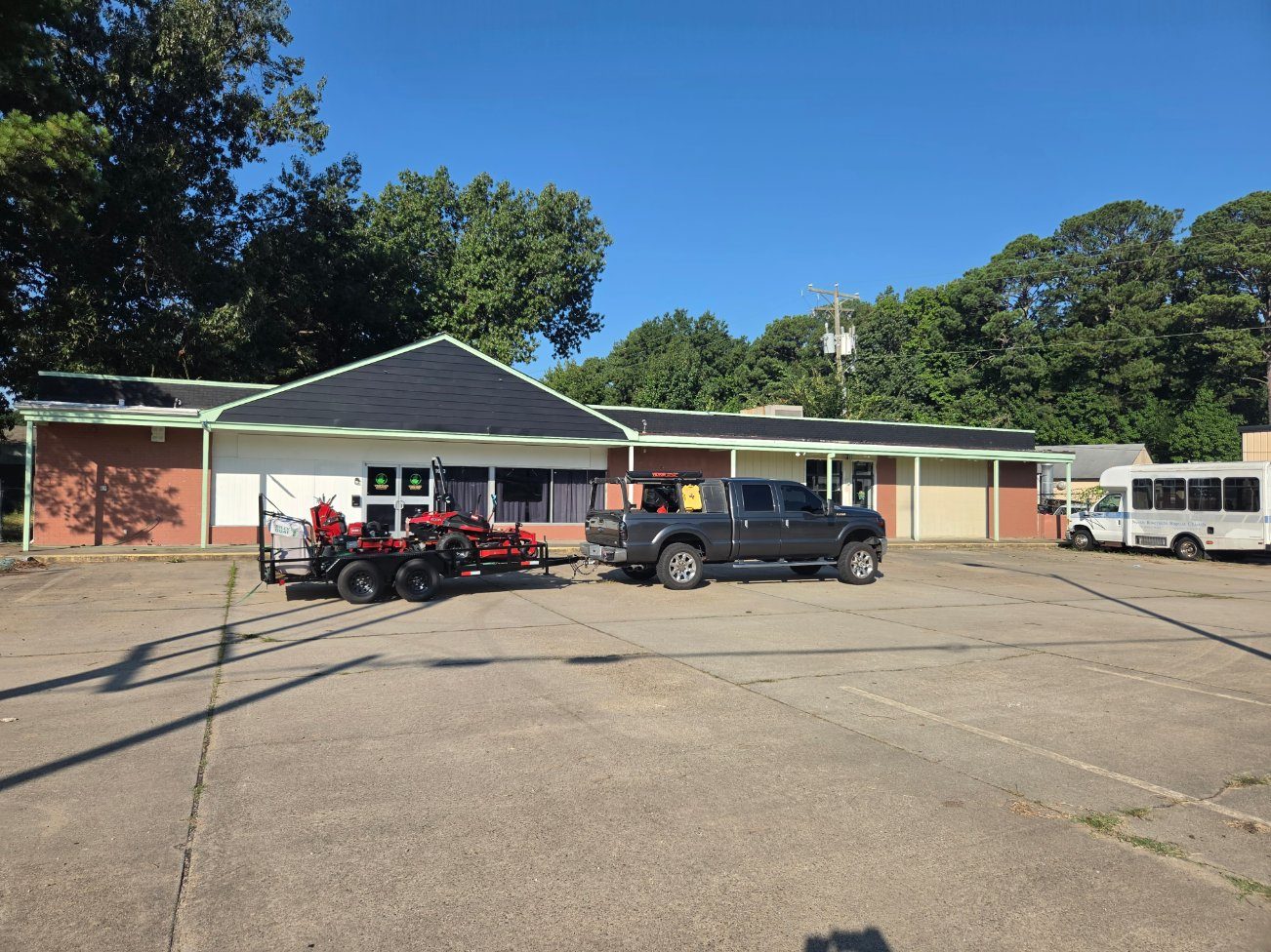 BMC truck, trailer, and mowers on a commercial job site